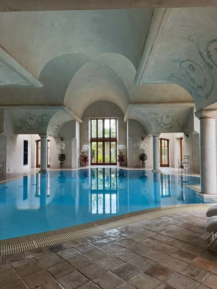 Painted vaulted ceiling with decorative scrollwork above an indoor pool