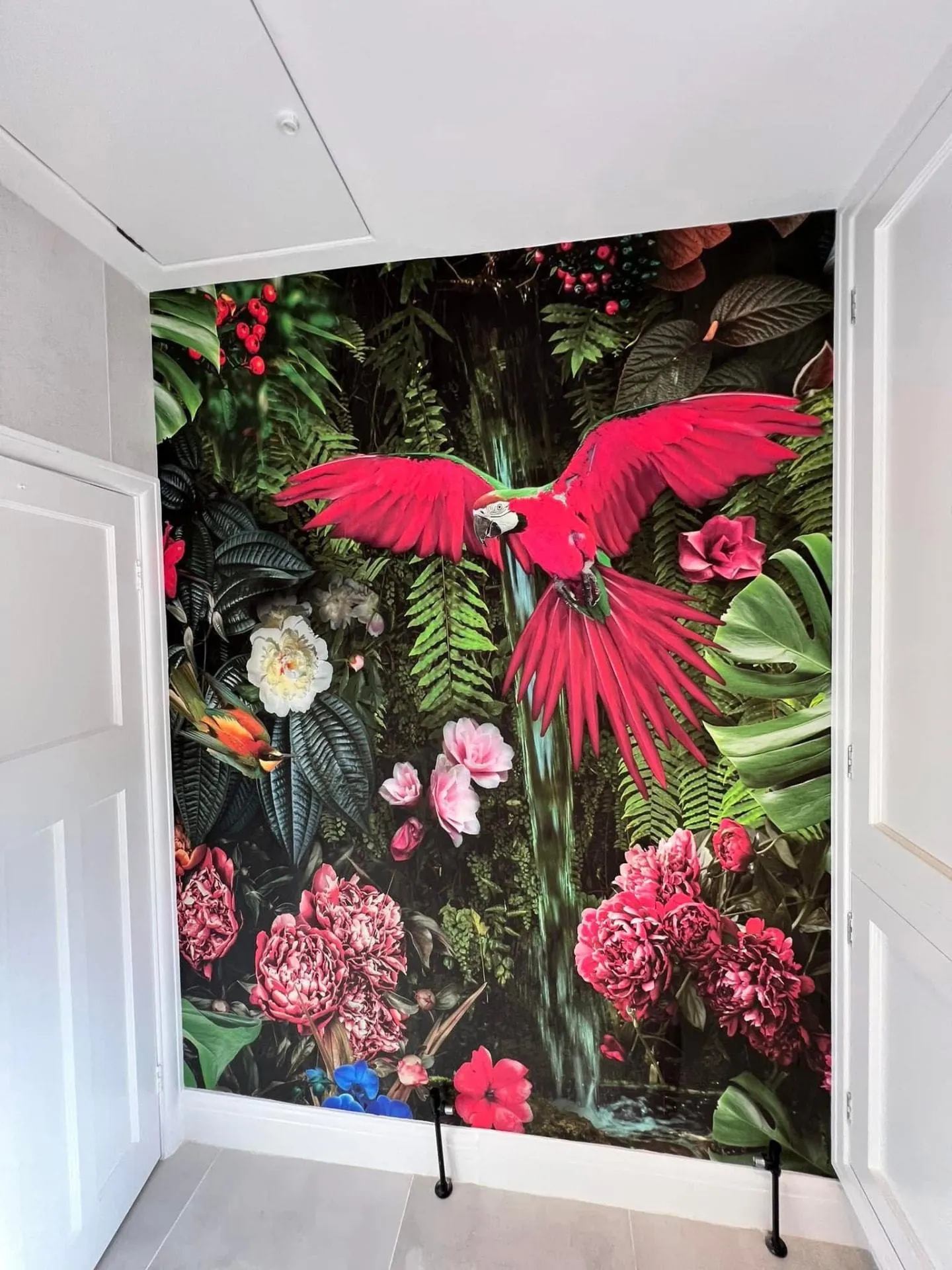 Tropical jungle mural wallpaper with a macaw hung full height in an alcove